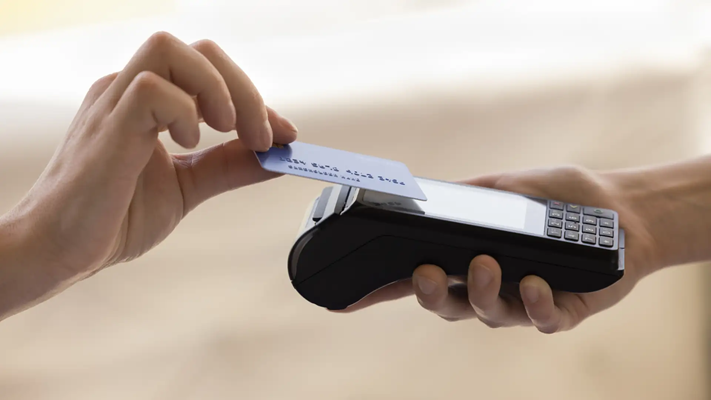 Payment processing solutions – A hand reaching out for an EFTPOS machine